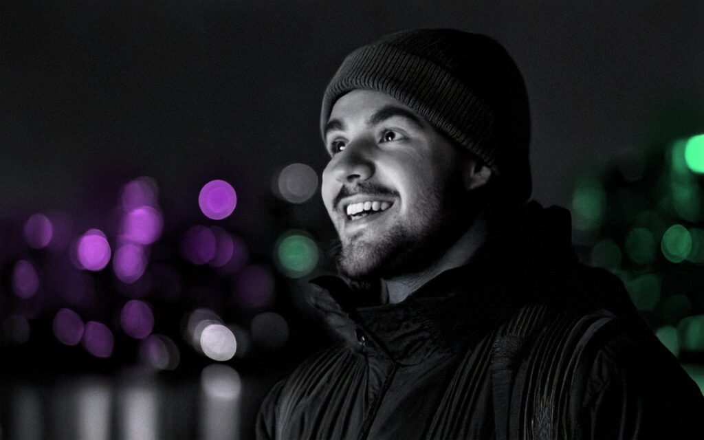 Happy man in a beanie hat by the river