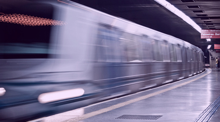 Silver train passing through an underground station